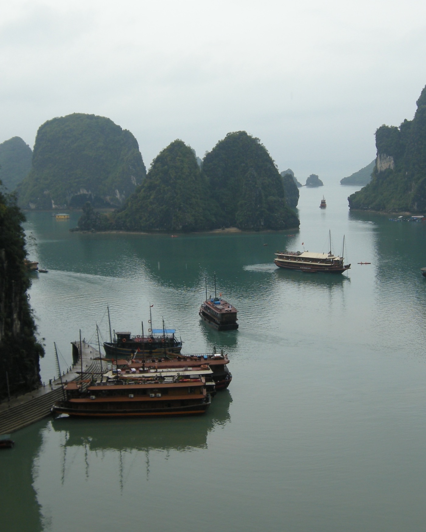 Traditional wooden boats among the limestone islands of Ha Long Bay